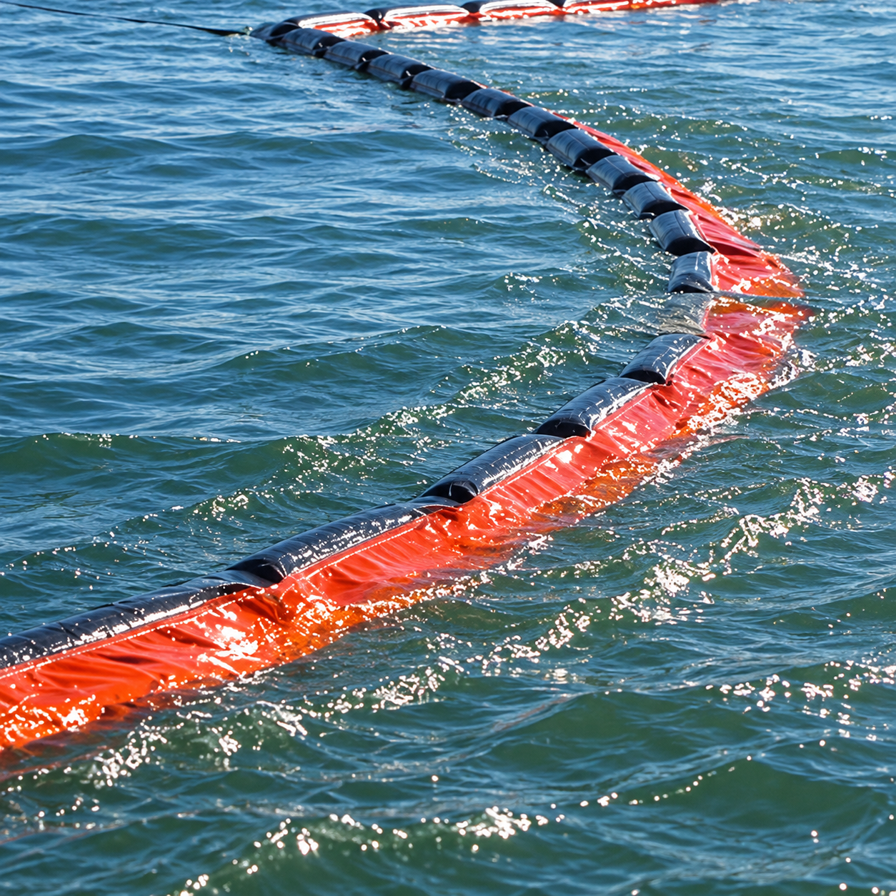 Illustration of an orange-and-black containment boom curving across moving water